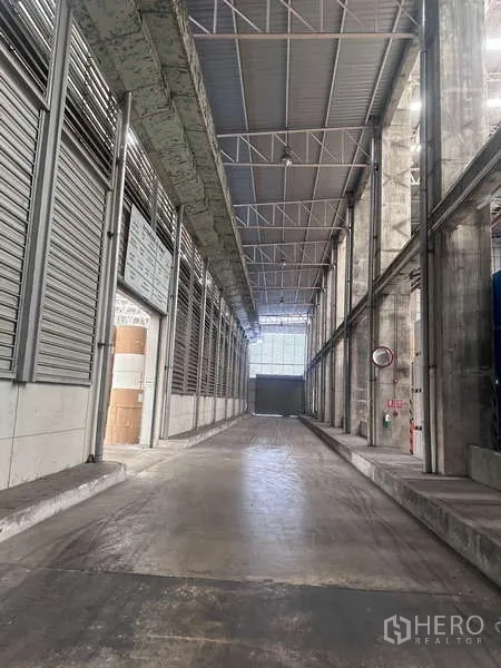 โรงงาน ให้เช่า - พื้นที่โหลดสินค้ามีหลังคาและทางเดินบริการ หลังคาสูงพร้อมทางลาดคอนกรีต
