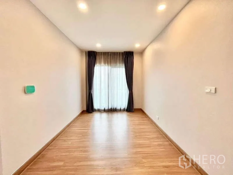 Detached House for rent in Don Mueang, Bangkok - Long flexible space with floor-to-ceiling curtains leading to balcony.
