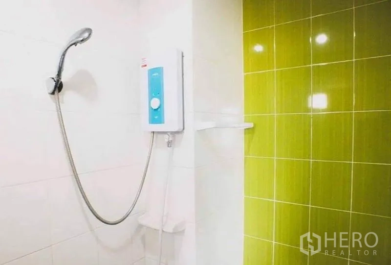 Shophouse for sale in Lam Luk Ka, Pathum Thani - Bathroom shower with water heater and green tiled wall.