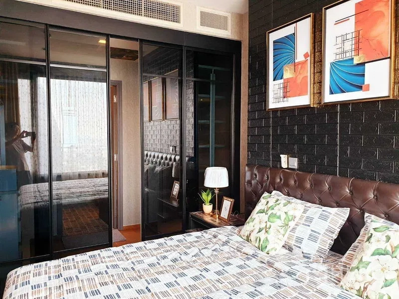 公寓 出租或出售在Khlong Toei, Bangkok - 卧室设软包床头、玻璃推拉衣柜与墙面装饰画。