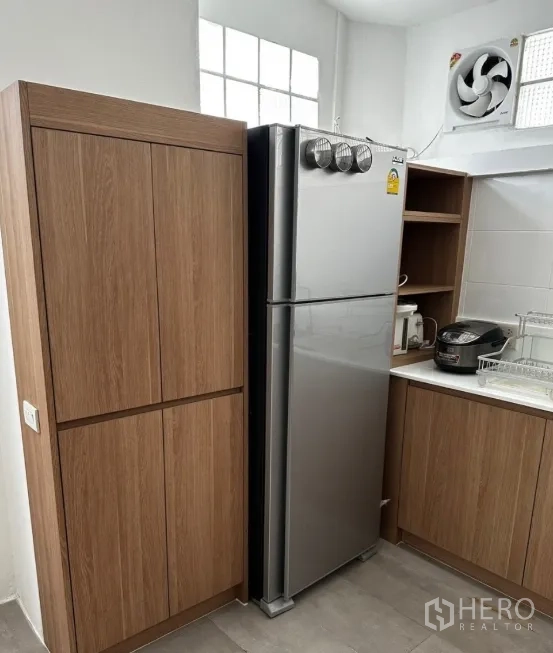 Townhouse for rent in Sathon, Bangkok - Tall pantry and stainless steel refrigerator beside kitchen counter.