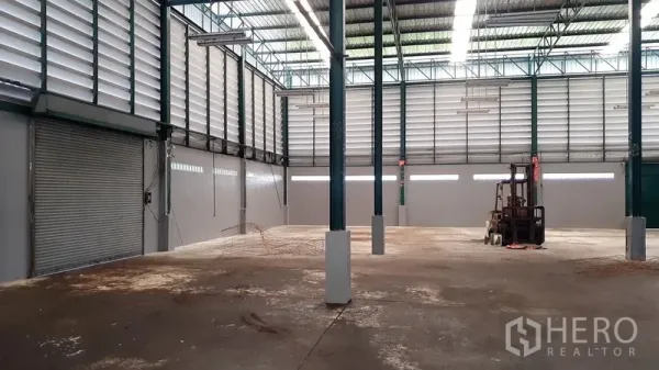 工厂 出租在Saphan Sung, Bangkok - 高挑仓储区，百叶通风墙、卷帘门与叉车作业空间。