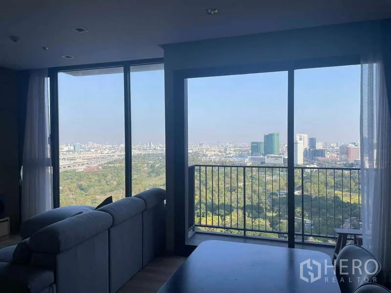 公寓 出租 - 客厅设沙发与餐桌，朱丽叶阳台框出广阔城景。