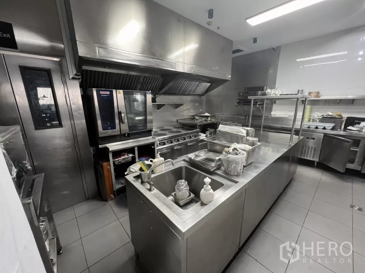 Retail Space for rent - Close-up of the kitchen line with stoves, hoods and prep sinks.