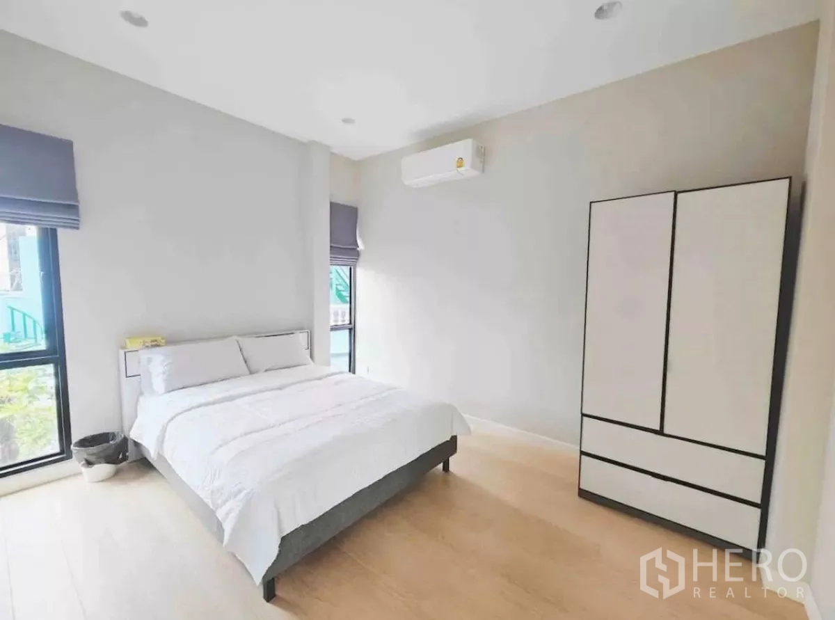 独立式住宅 出租在Phaya Thai, Bangkok - 客卧简洁，白色床与独立衣柜，浅木地板。