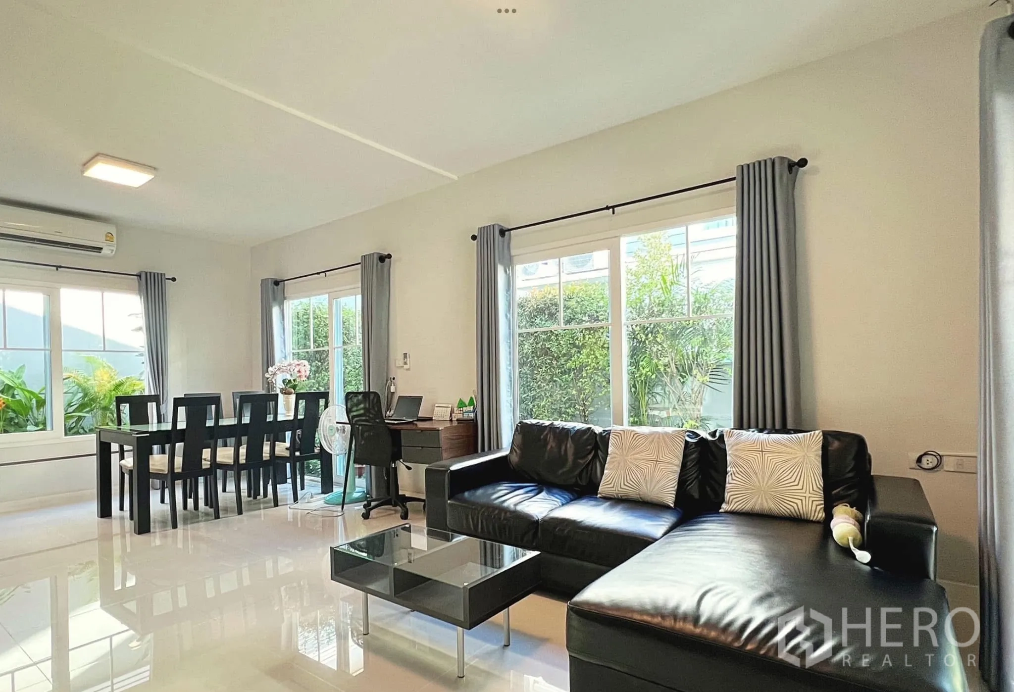 Townhouse for rent or sale in Sai Mai, Bangkok - Open-plan lounge and dining space with six-seat table and glossy tiled floors.