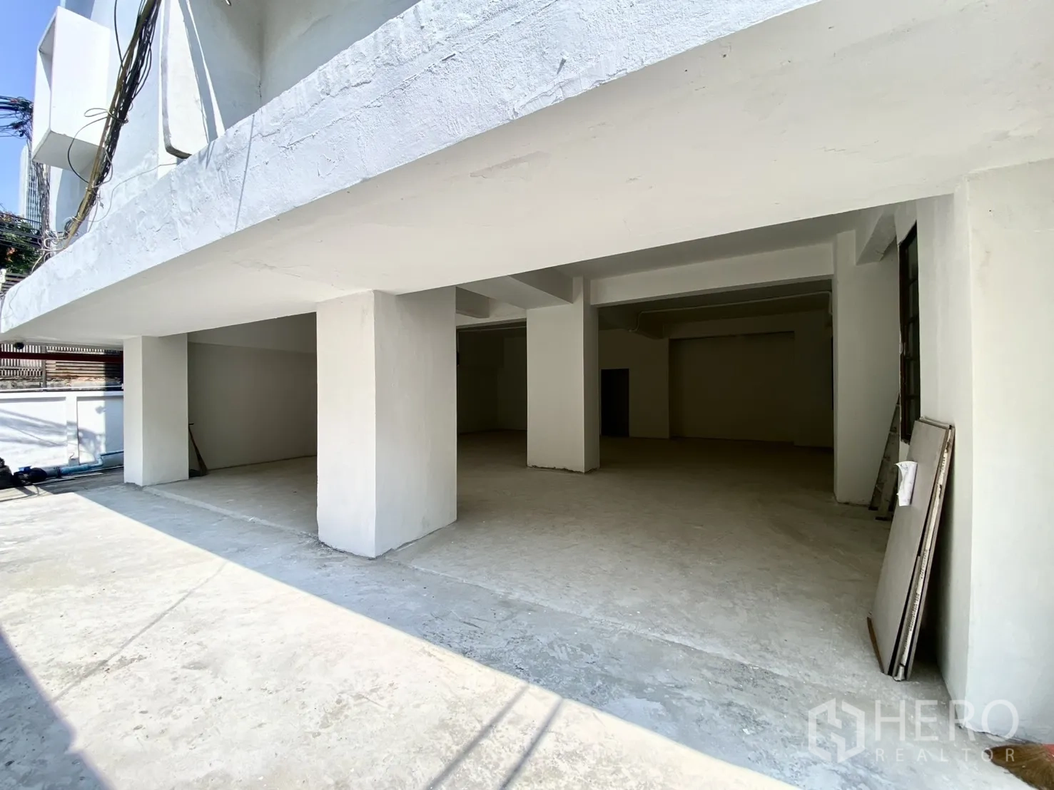 零售空间 for rent in Watthana, Bangkok - 一层零售毛坯空间，门面宽阔带遮檐与承重柱。