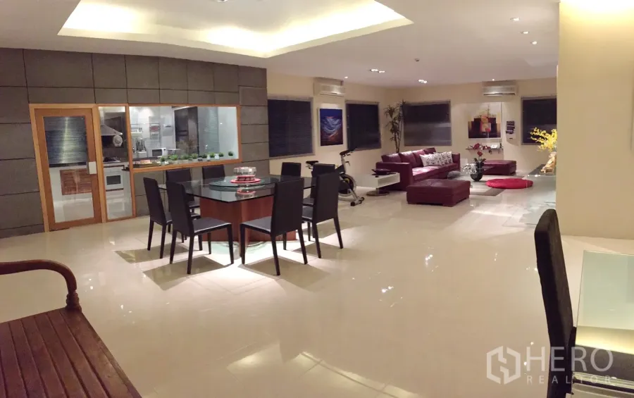 公寓 出租在Bang Rak, Bangkok - 开放式客餐厅，玻璃隔断厨房与红色皮沙发，地面光亮。