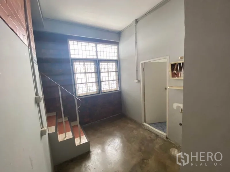 Retail Space for rent in Khlong San, Bangkok - Stairwell landing with glass-block window and doorway to restroom.