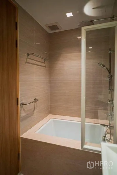 คอนโด ให้เช่าในWatthana, Bangkok - ห้องน้ำสมัยใหม่ตกแต่งกระเบื้องโทนเบจ มีอ่างอาบน้ำลึกและตู้กระจกกั้นอาบน้ำ