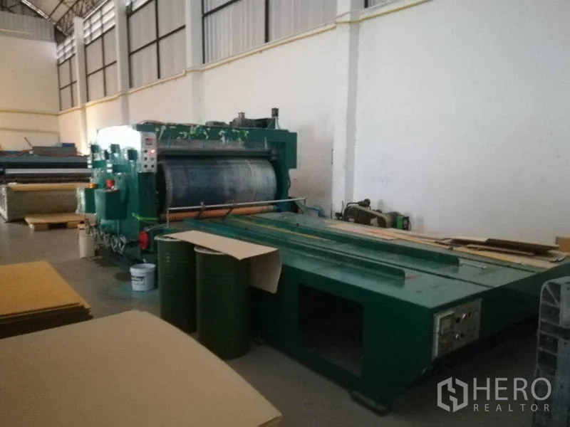 Factory for sale in Bang Len, Nakhon Pathom - Large industrial laminating or printing machine set against the factory wall.