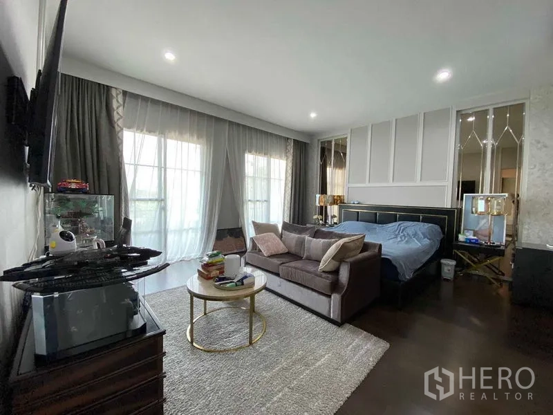 บ้าน ขายในPrawet, Bangkok - ห้องนอนใหญ่กว้างมีโซฟา ผ้าม่านสูงจรดเพดาน และทีวีติดผนัง