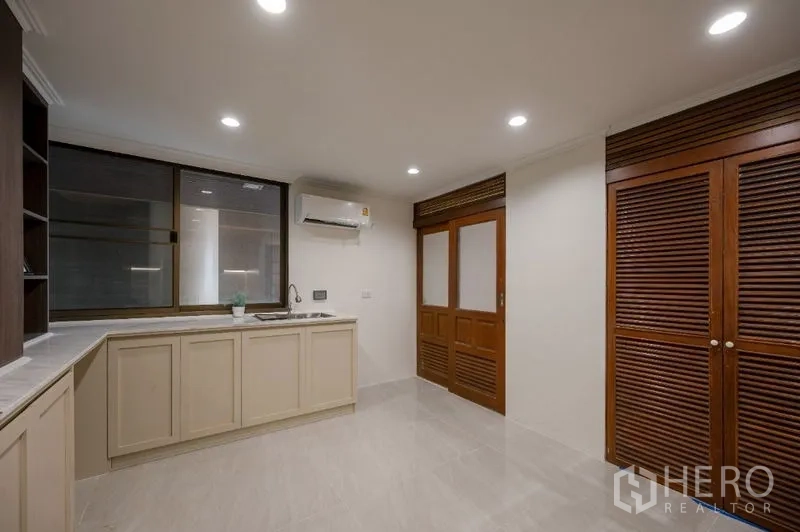 Condominium for sale - Kitchen view showing wooden louver doors and large window.