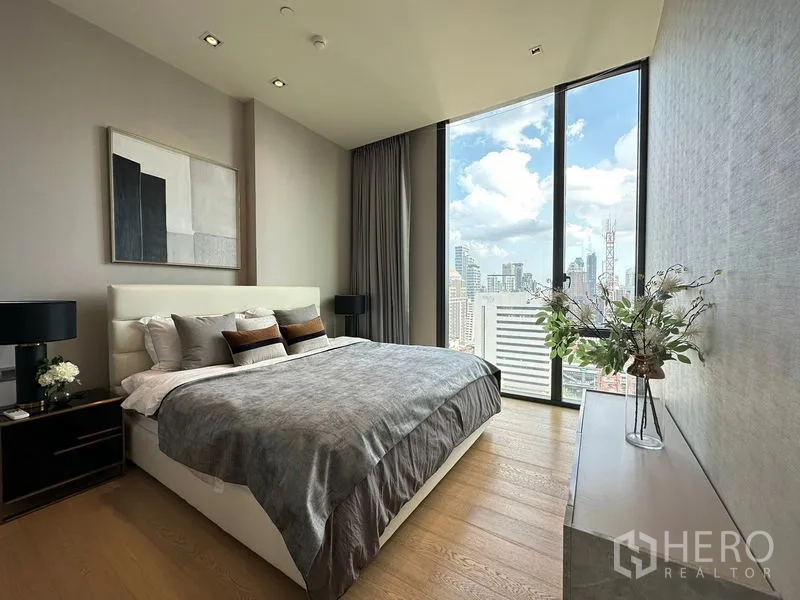 Condominium for rent in Pathum Wan, Bangkok - Primary bedroom with king bed, bedside tables and panoramic Bangkok city views.