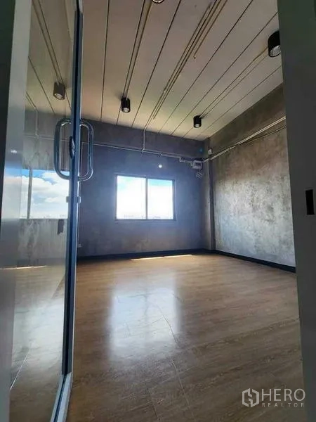 Office Space for rent or sale in Bueng Kum, Bangkok - Private office behind a glass door with a window for natural light, wood flooring and industrial ceiling.