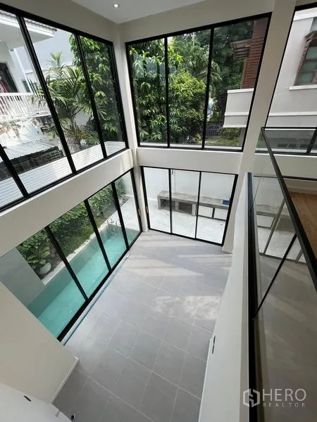 สำนักงานที่บ้าน ขายในPhra Khanong, Bangkok - ภาพมุมสูงของพื้นที่ดับเบิลวอลุ่มและสระแนวแคบผ่านผนังกระจกสูง.