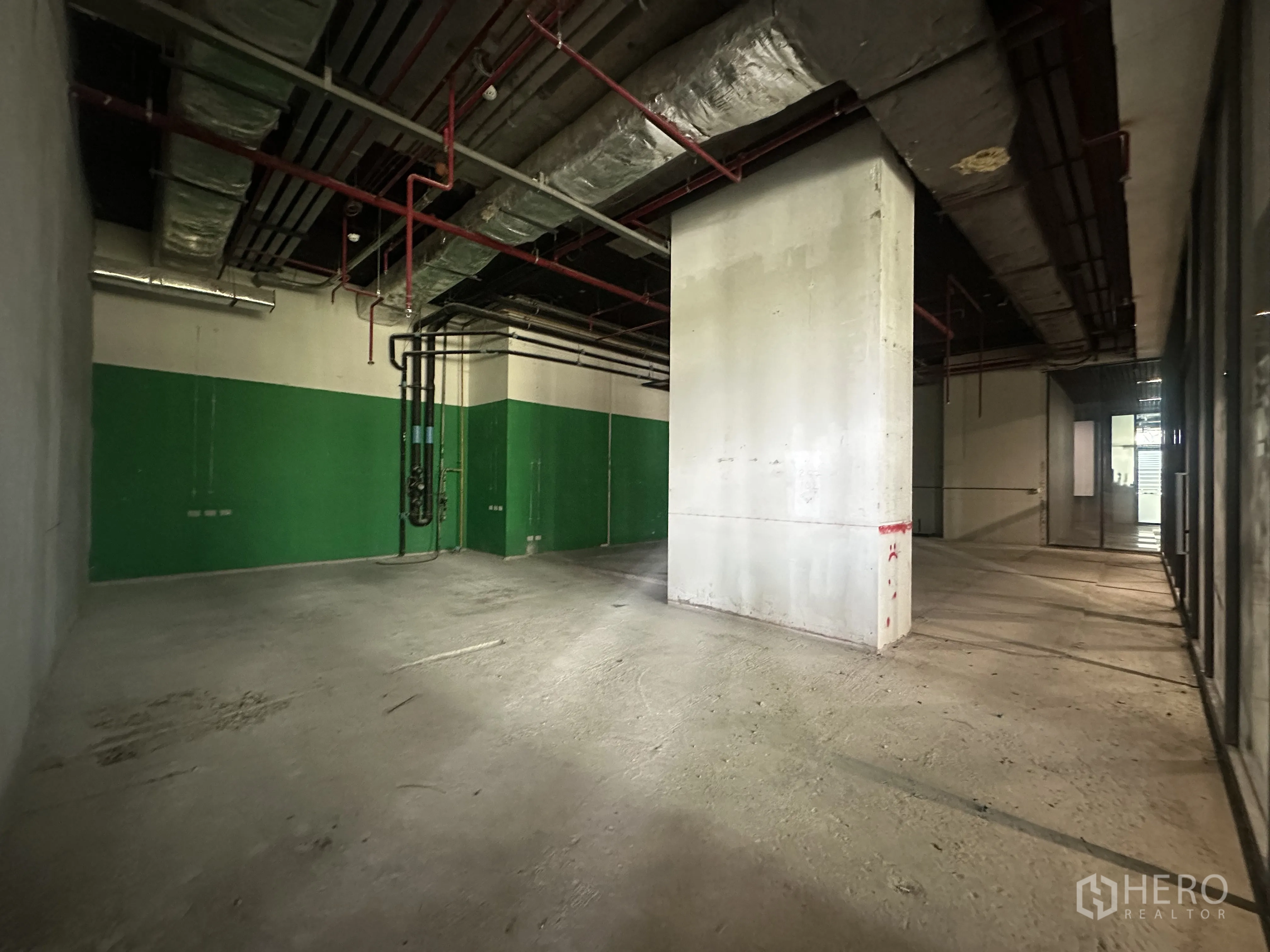 Retail Space for rent in Khlong Toei, Bangkok - Shell-and-core interior with high ceilings, exposed ducting and sprinklers.