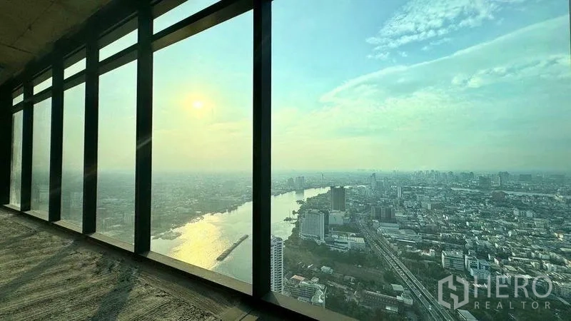 Condominium for sale in Bangkok - Sunset over the Chao Phraya River seen through tall windows of a high-rise condo.