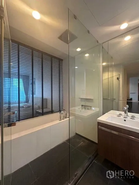 Condominium for rent in Pathum Wan, Bangkok - Bathroom with glass shower, bathtub and double vanity.