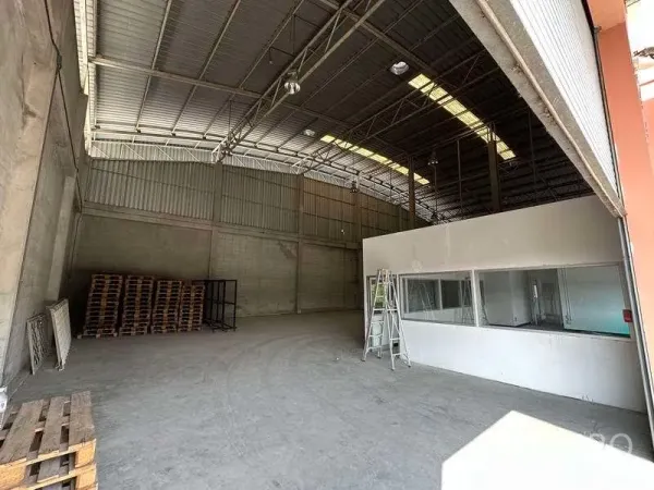 Factory for rent in Bang Phli, Samut Prakan - Storage bay with pallets beside a glass-partitioned office room.