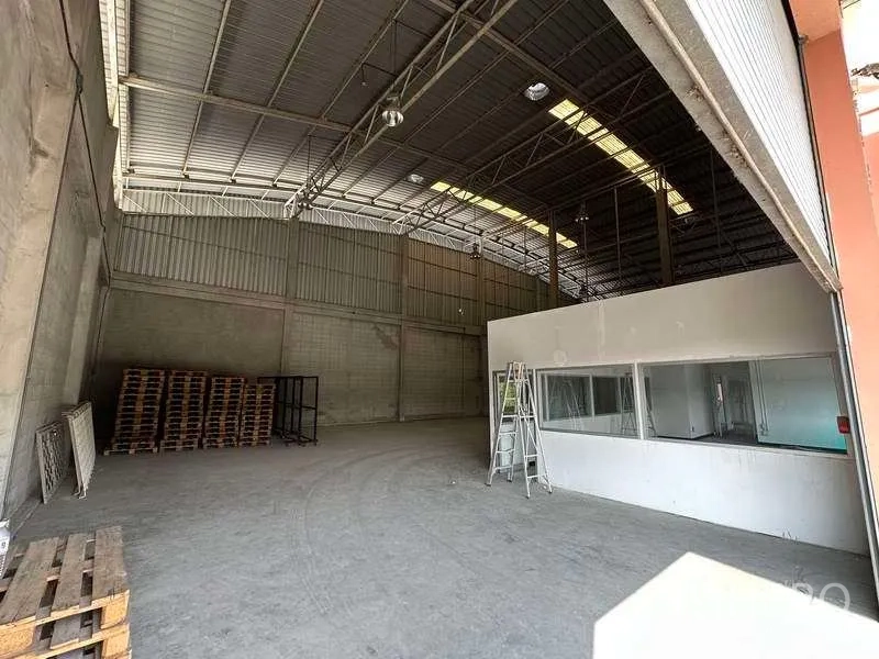 Factory for rent in Bang Phli, Samut Prakan - Storage bay with pallets beside a glass-partitioned office room.