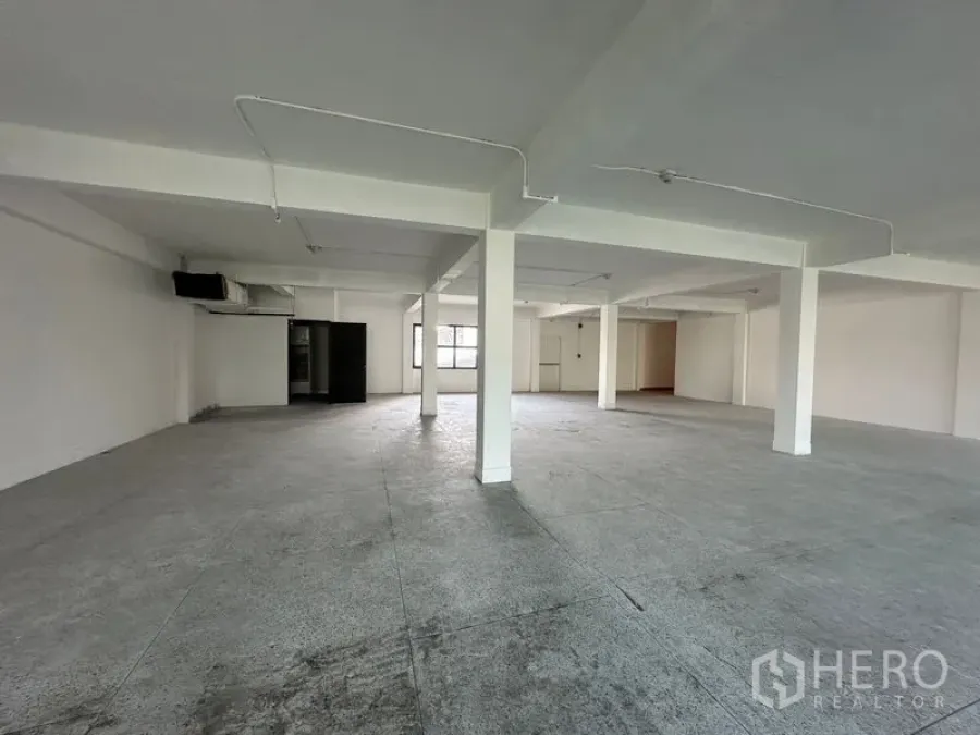 Office Space for rent in Khlong Toei, Bangkok - Bright empty office floorplate with windows on two sides and a marked emergency exit door.