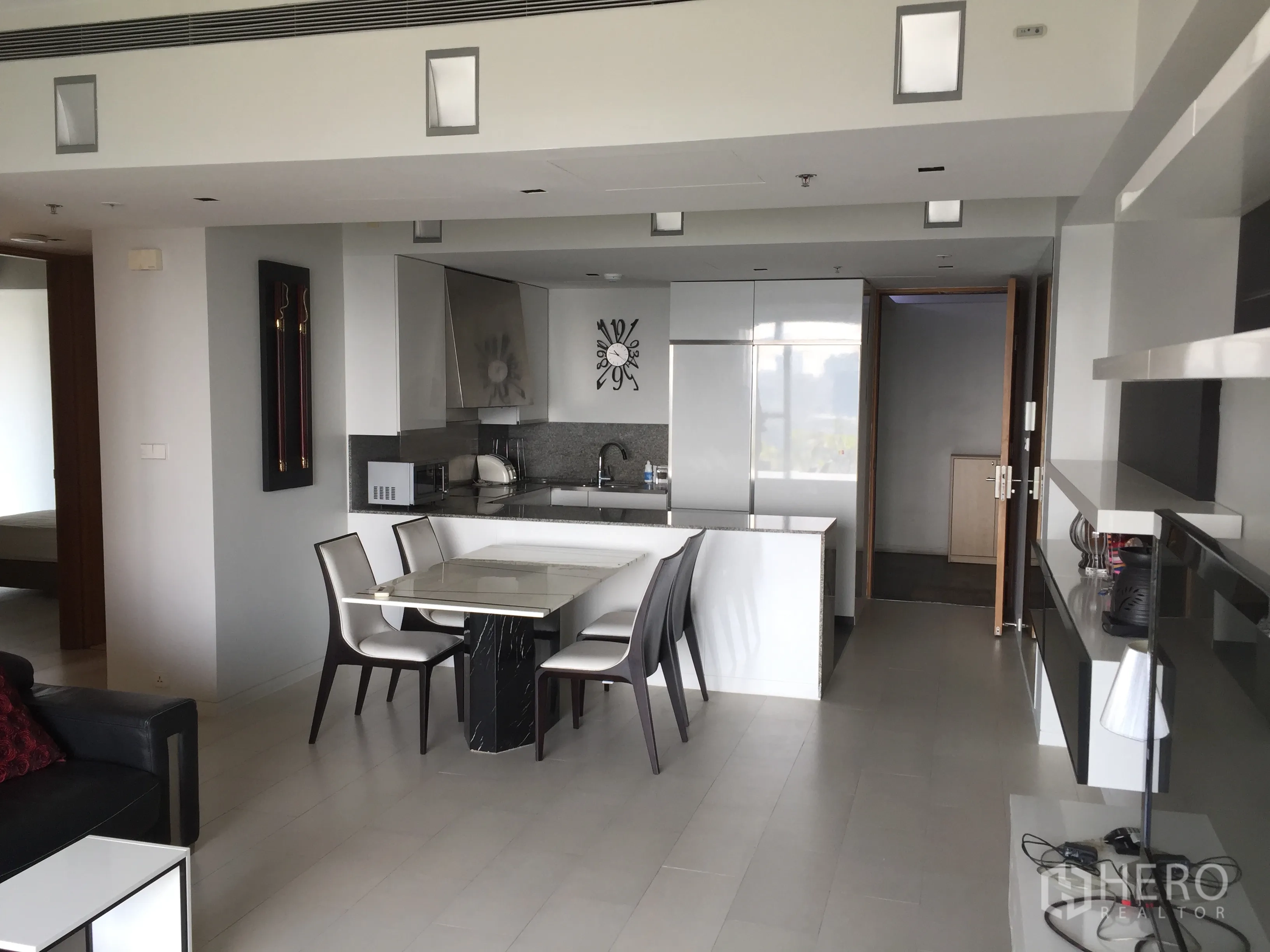 Condominium for rent in Sathon, Bangkok - Open-plan living, dining, and sleek white kitchen in a contemporary Bangkok condominium.