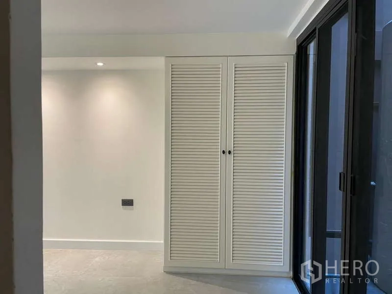 สำนักงานที่บ้าน ให้เช่าในWatthana, Bangkok - ห้องกะทัดรัดมีตู้เสื้อผ้าบานเกล็ดและประตูกระจกบานเลื่อนไปยังคอร์ตยาร์ด.