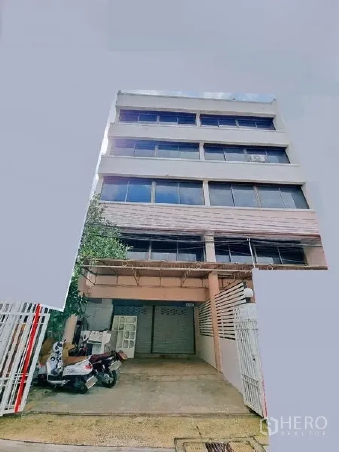 办公空间 出租在Din Daeng, Bangkok - 多层商业建筑外立面，带有院内车道和底层卷帘门。
