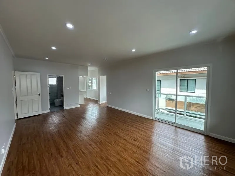 บ้าน ขายในLam Luk Ka, Pathum Thani - ห้องนอนชั้นบน พื้นไม้ ประตูบานเลื่อนออกระเบียง และทางเข้าห้องน้ำ