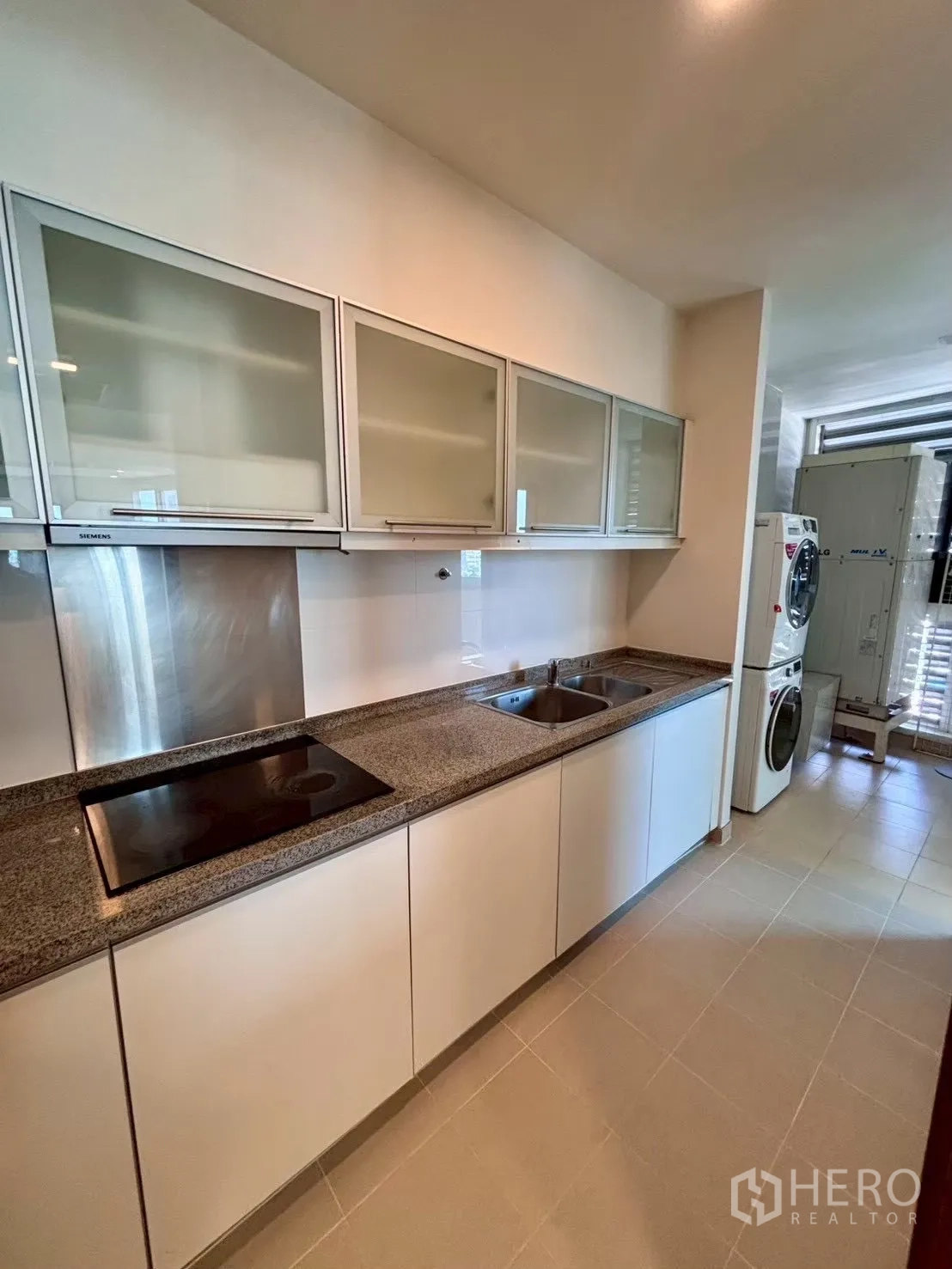 Condominium for rent in Khlong Toei, Bangkok - Long galley kitchen with double sink and laundry zone at the end