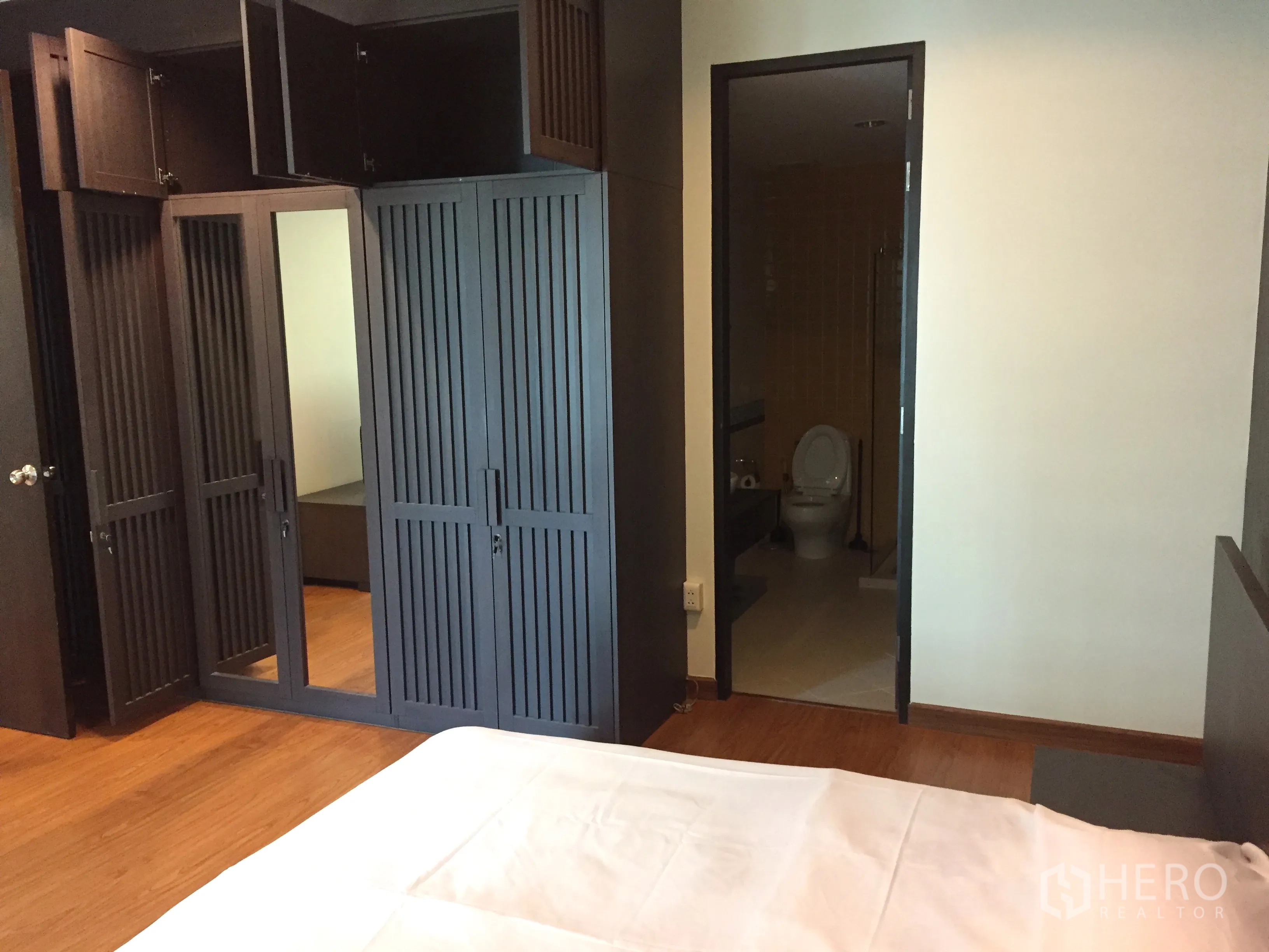 คอนโด ให้เช่าในKhlong Toei, Bangkok - ห้องนอนมีตู้เสื้อผ้าบิวท์อินสีเข้ม พร้อมประตูเชื่อมเข้าสู่ห้องน้ำในตัว