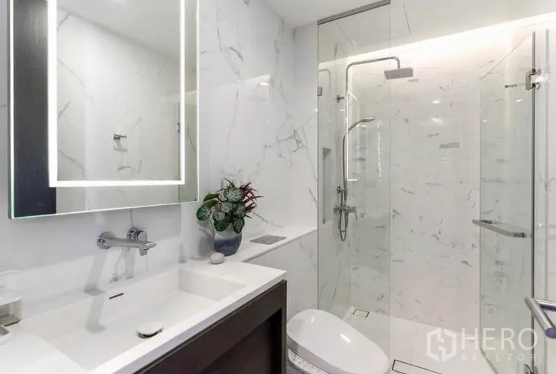 คอนโด ให้เช่าในKhlong Toei, Bangkok - ห้องน้ำโทนขาวหินอ่อนพร้อมตู้กระจกอาบน้ำและอ่างล้างหน้าเพรียว