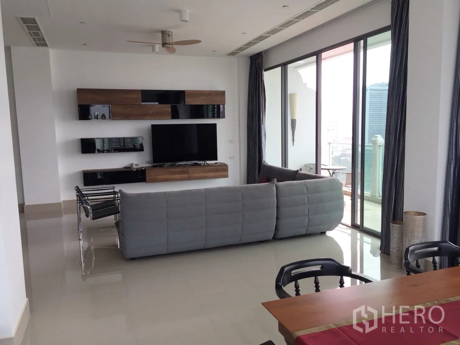 คอนโด ให้เช่าในWatthana, Bangkok - พื้นที่นั่งเล่นและรับประทานอาหารแบบเปิดโล่ง ผนังทีวี และประตูกระจกสไลด์ออกระเบียง