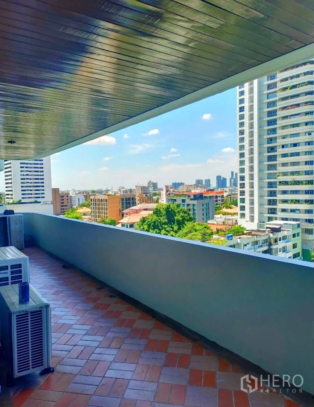 คอนโด ให้เช่าในWatthana, Bangkok - ระเบียงยาวมีหลังคาปูกระเบื้อง ชมวิวสกายไลน์และพื้นที่สีเขียว พร้อมคอมเพรสเซอร์แอร์
