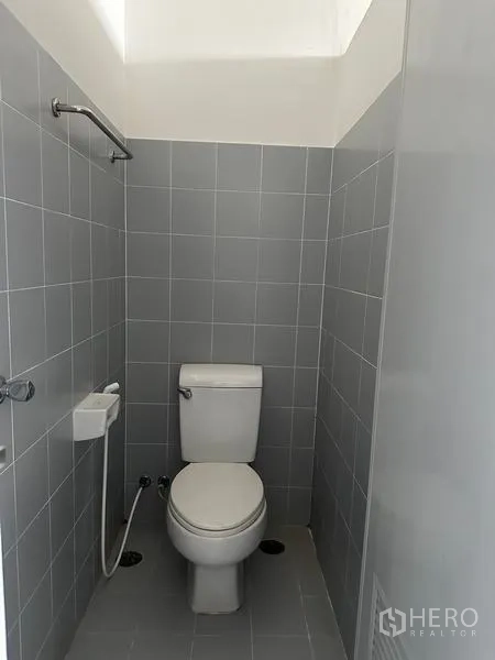 工厂 出租在Pathum Thani - 独立厕所隔间，带喷枪，灰色墙砖。