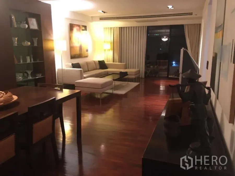 คอนโด ให้เช่า - พื้นที่นั่งเล่นและรับประทานอาหารแบบเปิดโล่ง มีชั้นโชว์ โซฟาเข้ามุม และทางออกระเบียง