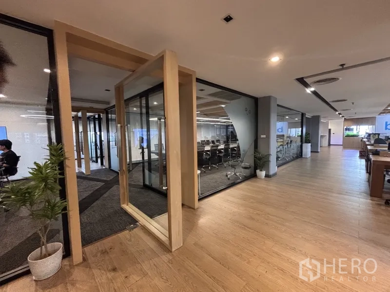 办公室 for rent in Bang Rak, Bangkok - 玻璃会议室入口，旁为开放式办公区。