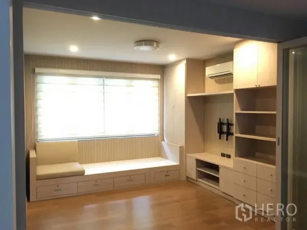 Detached House for rent or sale in Bang Kapi, Bangkok - Bright family room with built-in window bench, shelving and wood floors.