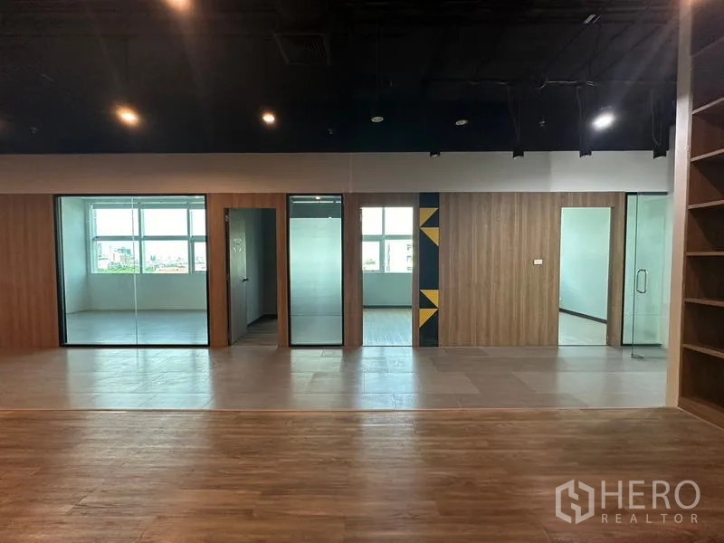 Office Space for rent in Ratchathewi, Bangkok - Row of glass-partitioned offices with wood cladding and city-view windows.