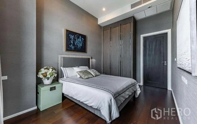 Condominium for rent - Cozy bedroom with built-in wardrobe, bedside table and gray feature wall.