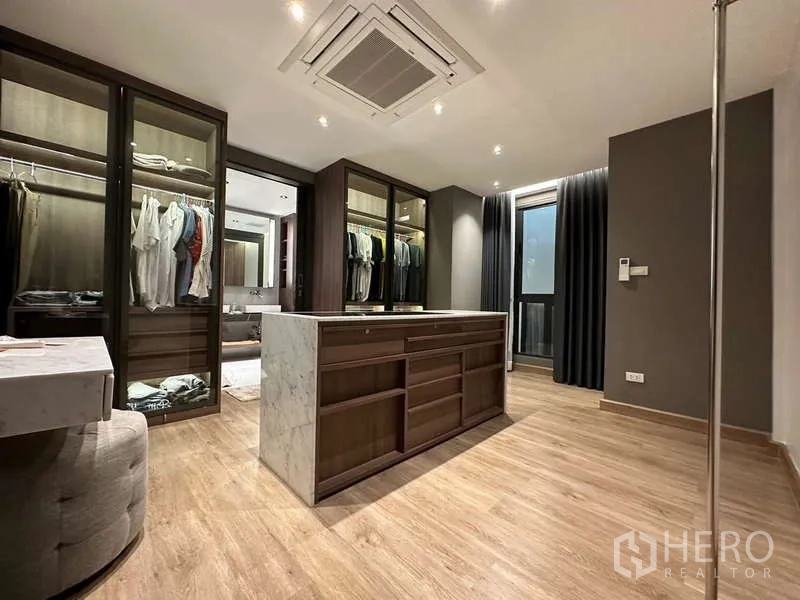 Townhouse for rent in Yan Nawa, Bangkok - Spacious walk-in closet with glass wardrobes, island dresser and wood floors.