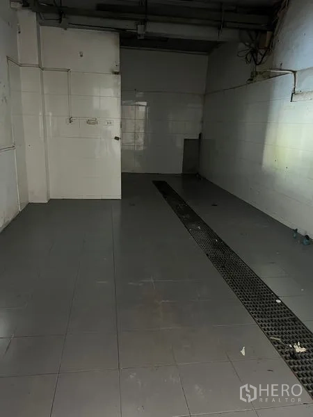 店屋 出租在Wang Thonglang, Bangkok - 后勤房间，墙面贴砖，地面排水槽与管线接口，可作简易厨房。