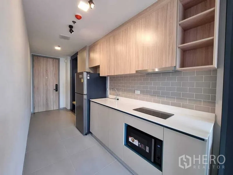 公寓 出租在Ratchathewi, Bangkok - 现代小厨房，浅木橱柜与地铁砖挡板。