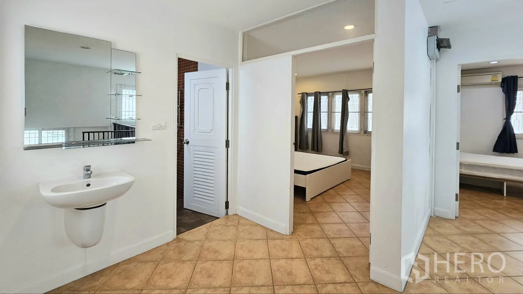 Detached House for rent in Saphan Sung, Bangkok - Upper hall with wall-mounted sink, mirror cabinet, and doors to bedrooms and bathroom.