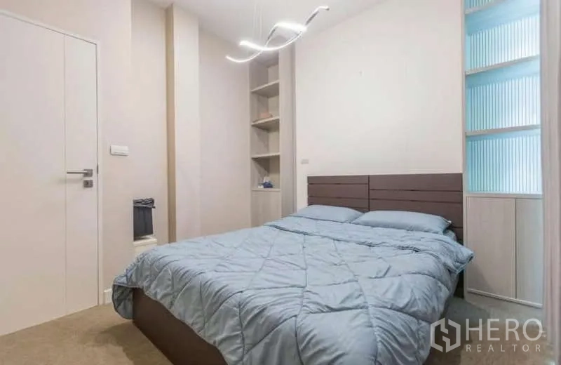 独立式住宅 出租或出售在Lat Phrao, Bangkok - 温馨卧室，内置搁架、吊灯与蓝色被褥。