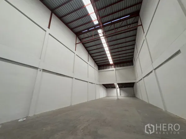 โรงงาน ให้เช่าในPhra Samut Chedi, Samut Prakan - มุมมองยาวของโกดัง แสดงหลังคาโปร่งแสงและผนังสีขาวสูง