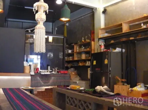 อาคารพาณิชย์ ให้เช่าในWatthana, Bangkok - โซนครัวเปิดพร้อมชั้นวาง ตู้เย็น โคมไฟแขวน และม้านั่งคอนกรีต ภายในอาคารพาณิชย์ในกรุงเทพฯ