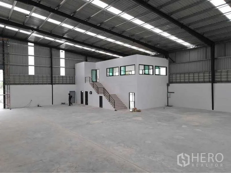 คลังสินค้า ให้เช่าหรือขายในNikhom Phatthana, Rayong - ภายในโกดังเพดานสูง โครงสร้างเหล็ก พื้นคอนกรีตขัดมัน และออฟฟิศสองชั้นสีขาวพร้อมบันได
