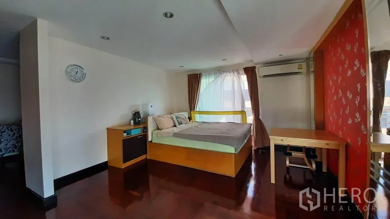 คอนโด ให้เช่าในWatthana, Bangkok - ห้องนอนใหญ่ หน้าต่างมุมห้อง ผนังแต้มสีแดง โต๊ะทำงาน และเครื่องปรับอากาศ